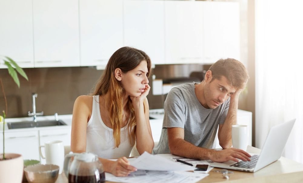 a man and woman sitting at a table with papers