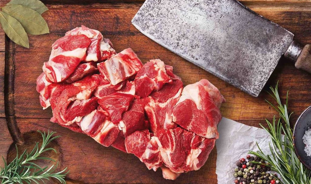 Fresh goat mutton curry cut on wooden board with herbs and spices.