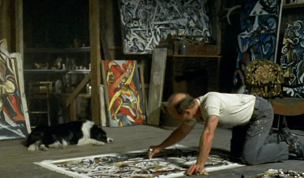 Ateliê de Jackson Pollock com telas no chão, mostrando sua técnica de dripping.