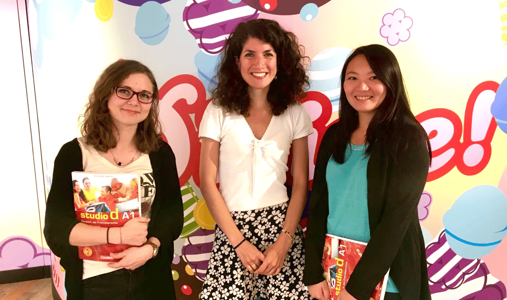 Linguages owner Linda with her German students at King in their London office, standing in front of a Candy Crush background