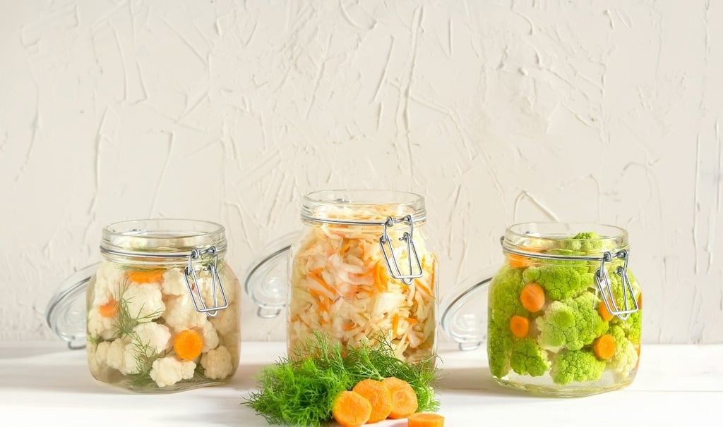 Una variedad de verduras en frascos con una variedad de verduras.