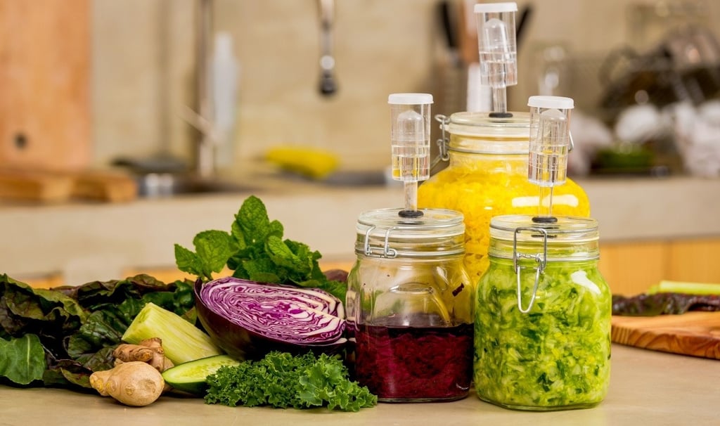 Una variedad de alimentos fermentados veganos en una encimera.