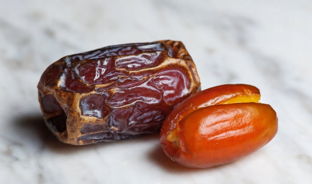 Comparativa visual: a la izquierda un dátil Medjool grande y arrugado, a la derecha un dátil Deglet Nour pequeño