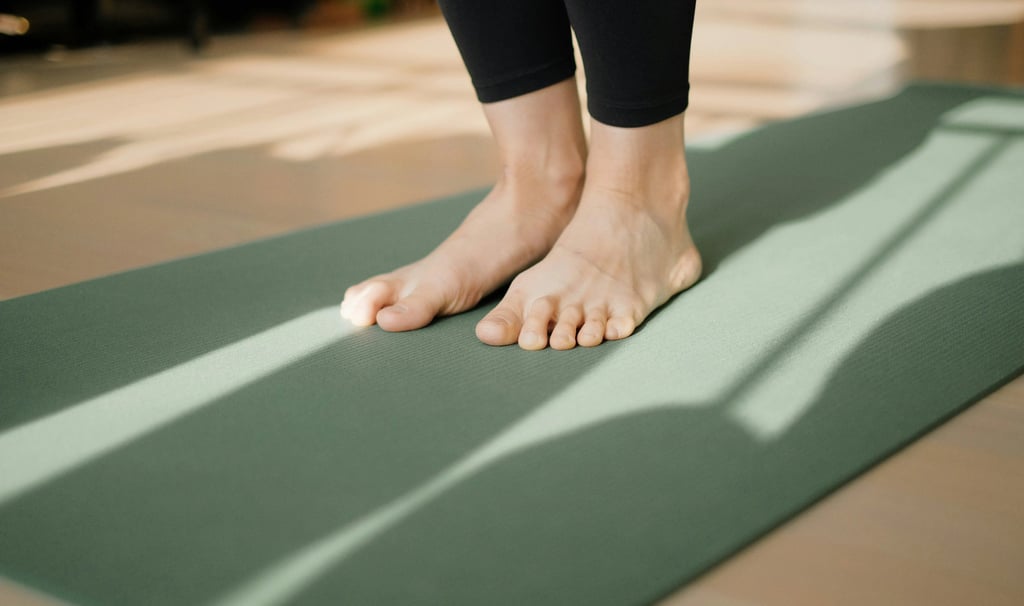 Close-up of feet on green yoga mat in afternoon sun, symbolizing yoga philosophy and psychology beyond the mat in daily life.