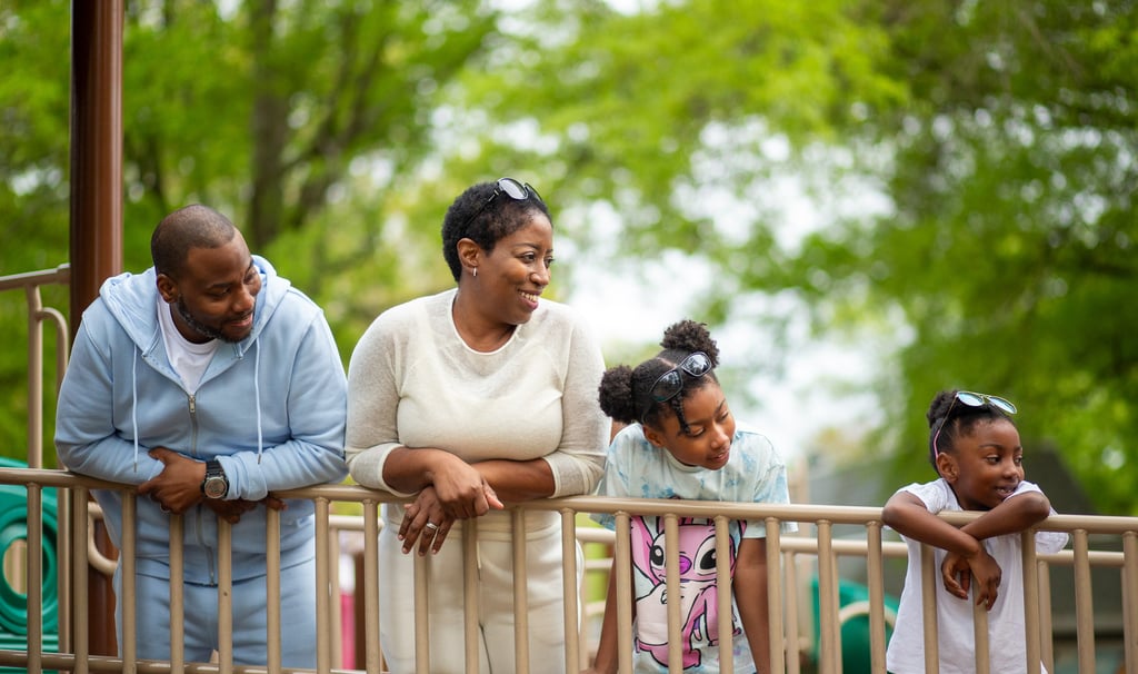 Black family with Mother and Father and daughters enjoying the day at park.