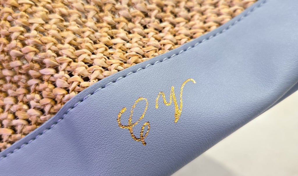 Hot foiling initials on leather bag at Saks Fifth Avenue by NYC calligrapher Handwritten by Belle.