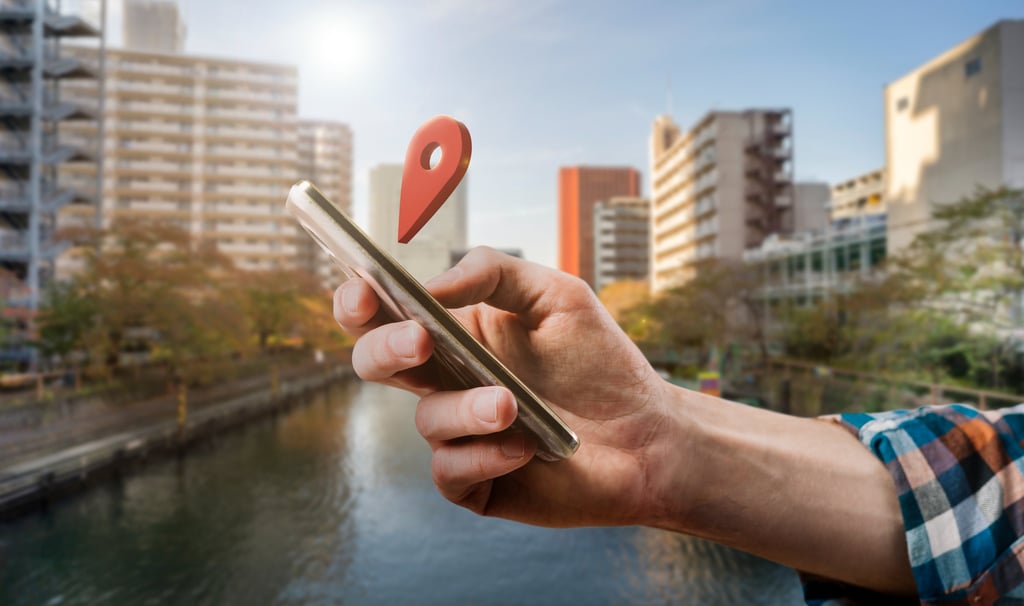 A hand using mobile and a location sign apprear floating above mobile