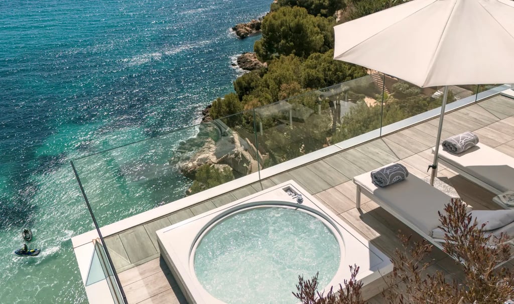 Luxury terrace with a private hot tub and sun loungers overlooking the turquoise Mediterranean Sea.