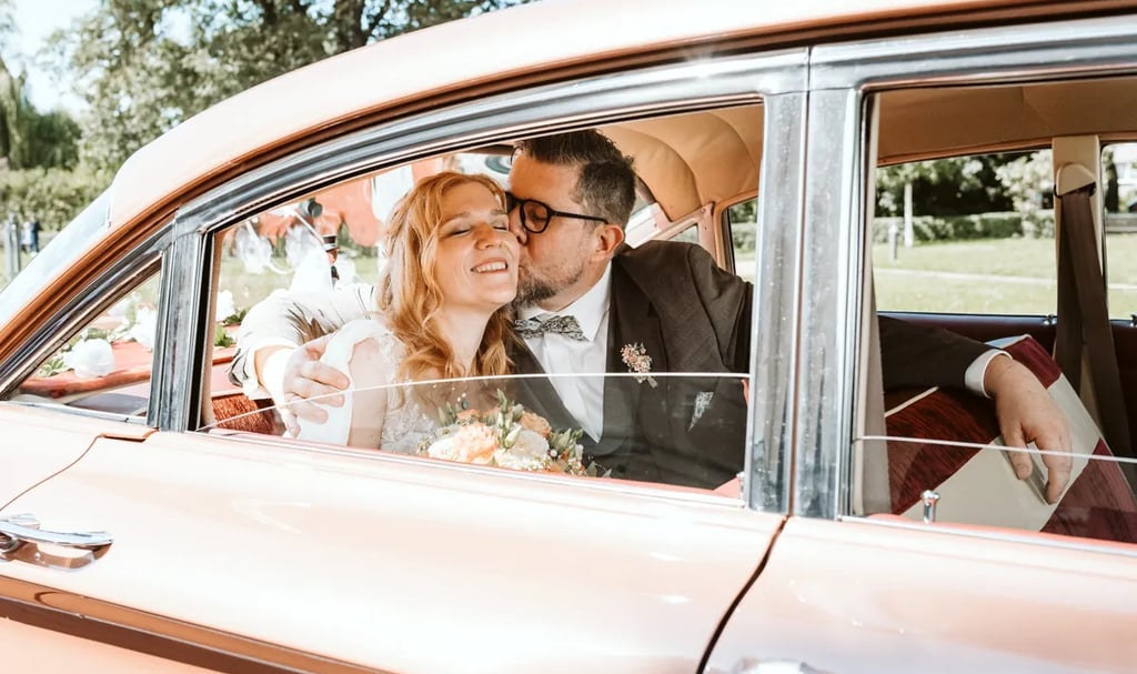 Hochzeitsfotograf am Möhnesee – Brautpaar im Oldtimer, emotionales und authentisches Hochzeitsfoto im Sommerlicht
