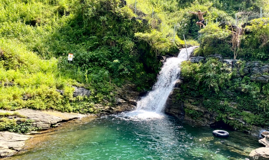 a man is standing in front of a waterfall