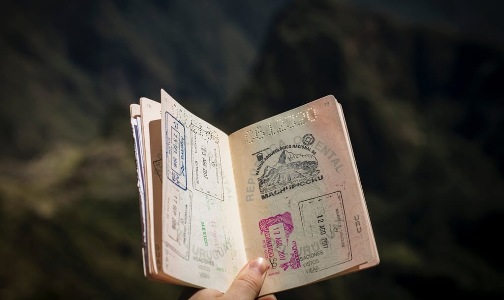 Hand holding an open passport with stamps, illustrating readiness for the U.S. student visa process