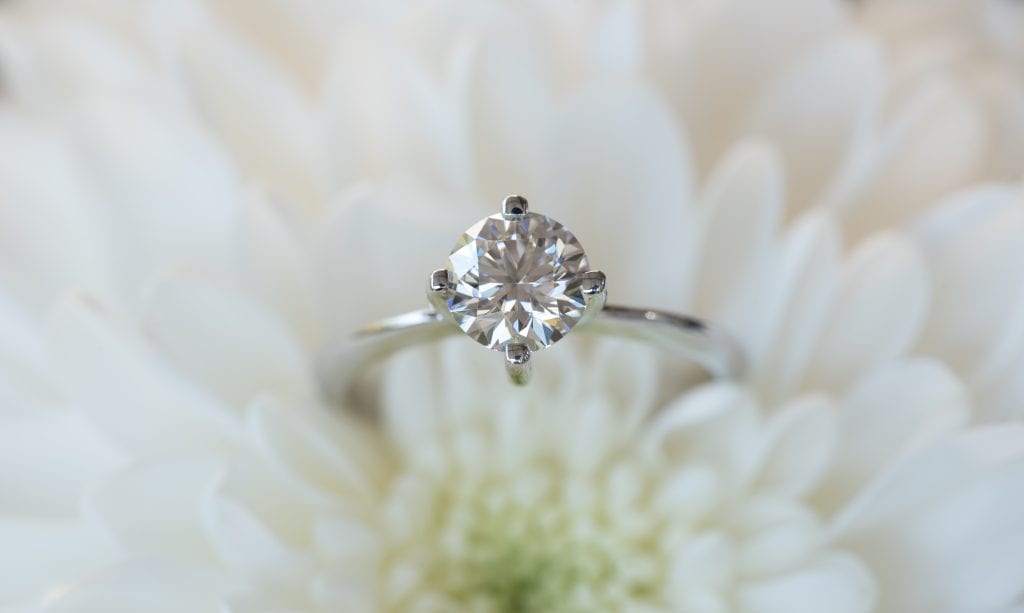 a Lab-Grown Diamonds CVD cut diamond ring with a diamond ring on top of a white flower