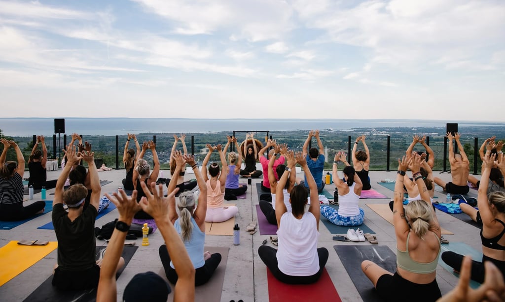 A group of people practicing outdoor yoga in  a wellness festival event