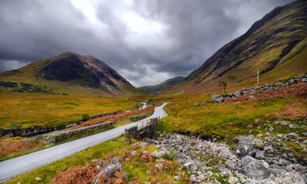 a winding road in the scottish mountains