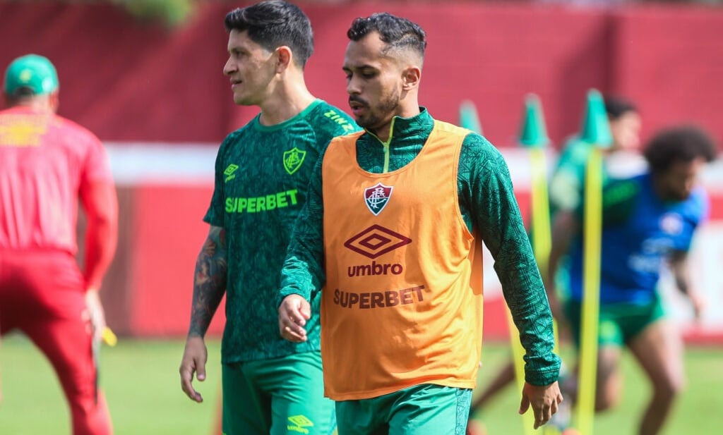 a man in a yellow shirt is walking on a soccer field