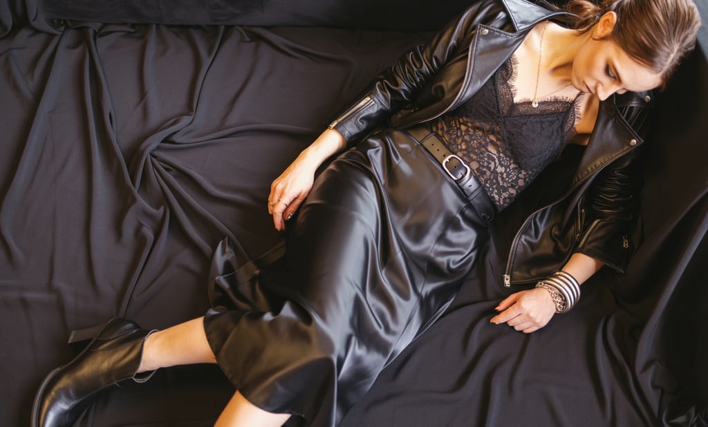 a woman in a black dress and leather jacket