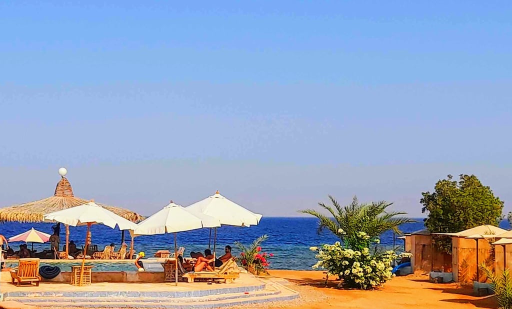 uma praia com guarda-sóis ao redor de uma piscina no Egito