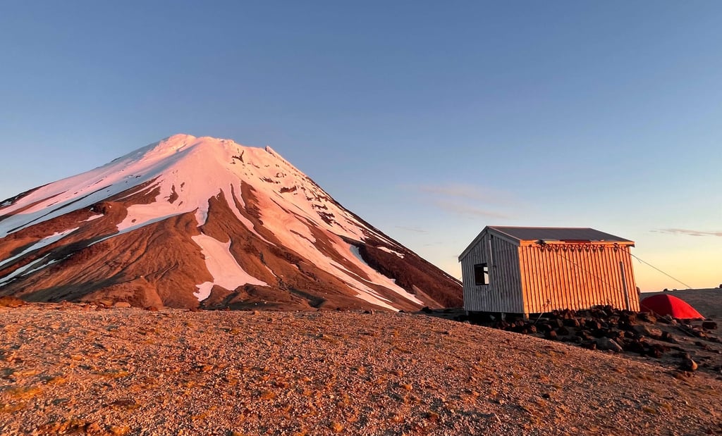 La luz del amanecer reflejada en el Taranaki junto a Syme Hut