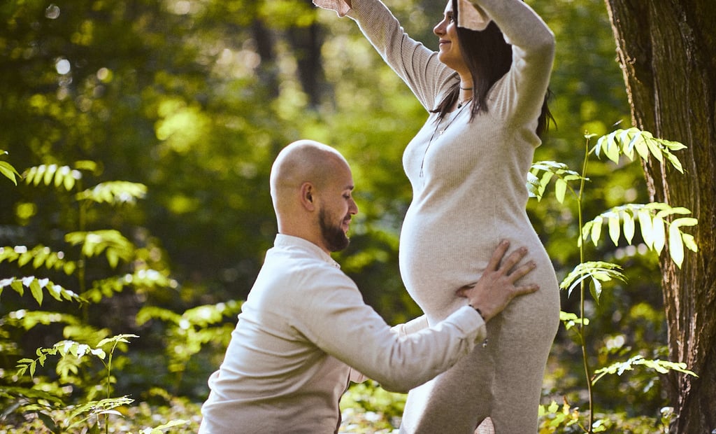 Mężczyzna trzyma brzuch kobiety w ciąży na tle egzotycznego krajobrazu