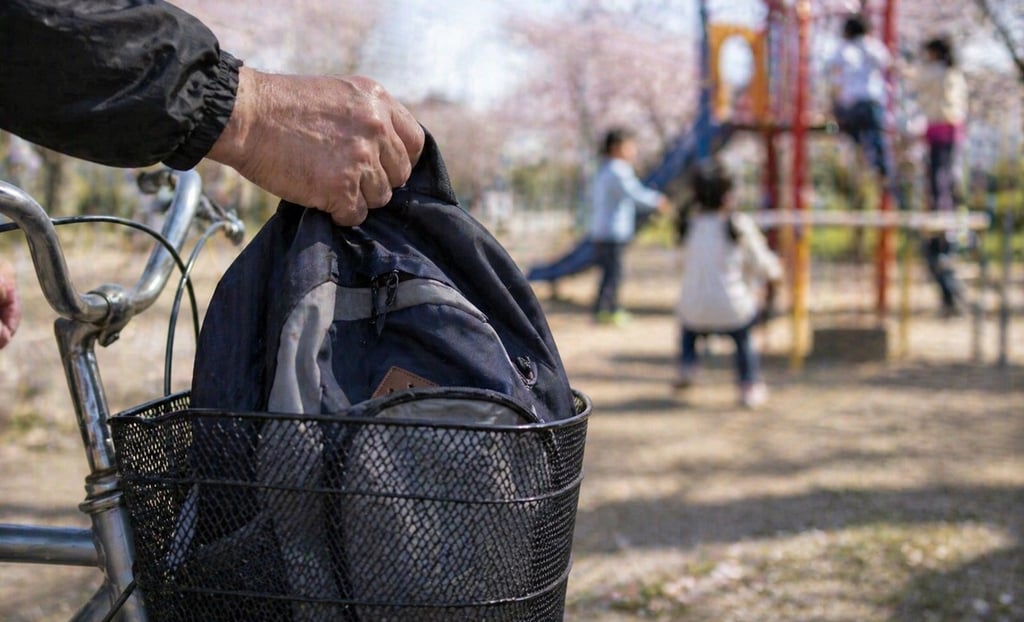 前かごに置いたままの荷物を盗ろうとしている人物の手のイメージ画像|堺市のニュースならサカイタイムズ