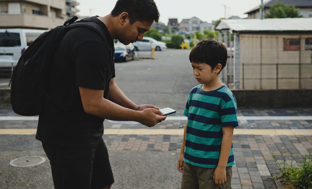 スマホを使って小学生に声をかける外国人のイメージ画像|堺市のニュースならサカイタイムズ