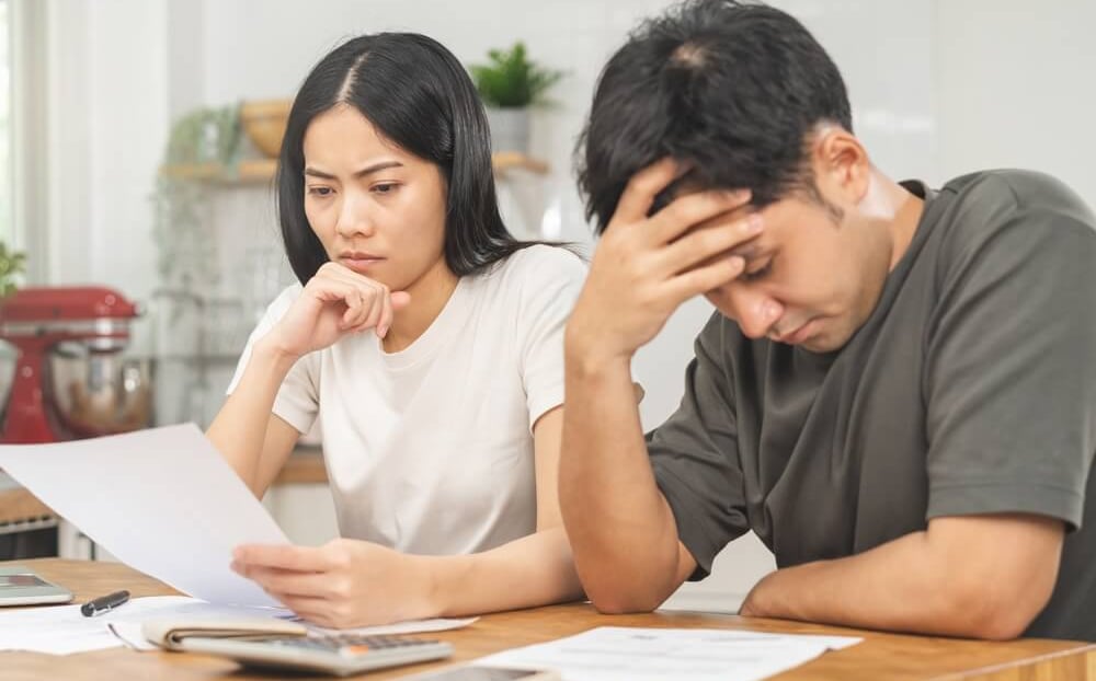 um casal hétero olhando as contas que tem que pagarem juntos e estão olhando para os Boletos