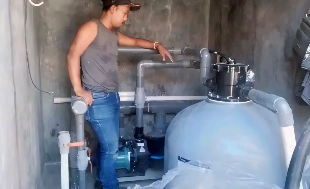 Teknisi melakukan pengujian sistem kolam renang setelah pengisian air
