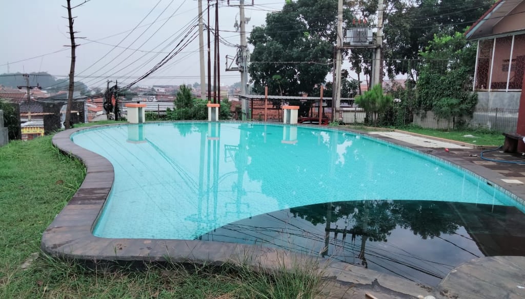 Kolam renang modern dengan pemandangan kota Bandung di latar belakang