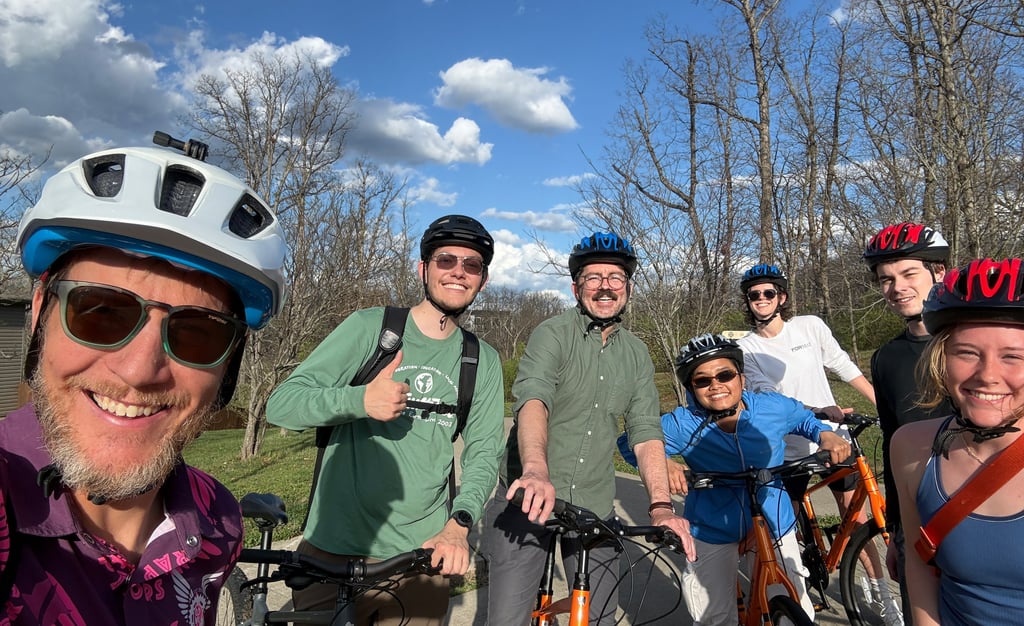 Group image of people in helmets on bikes posing