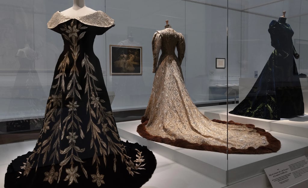 Historic couture gowns on display at fashion museum exhibit.