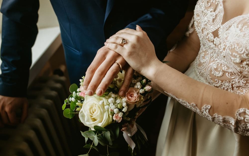 a bride and groom holding hands in a wedding ceremony