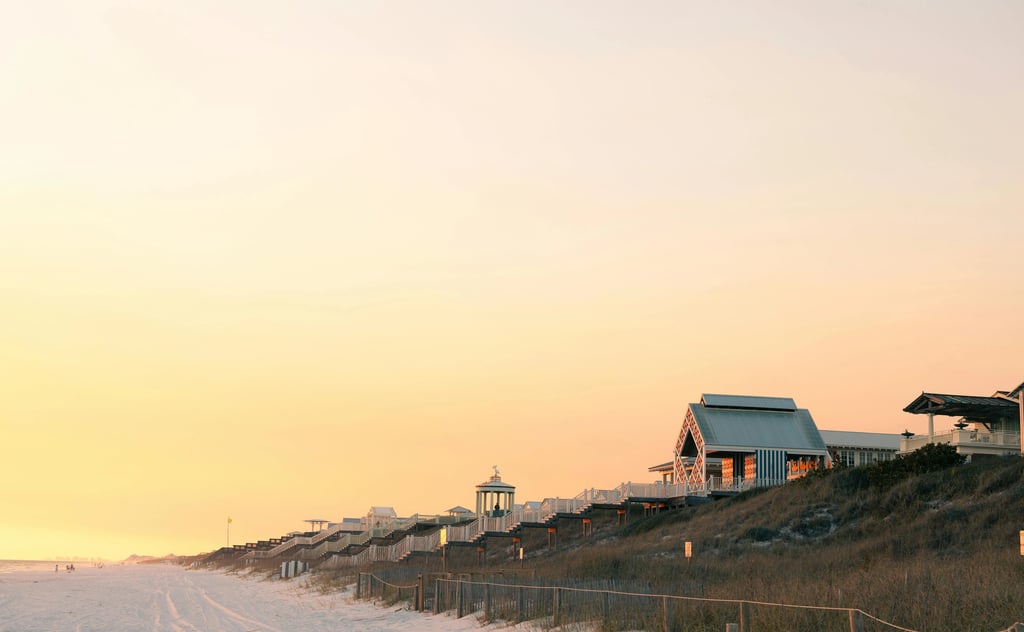 Luxury beachfront beach houses and pavilions on sand dunes during a golden sunset at Seaside, Florida.
