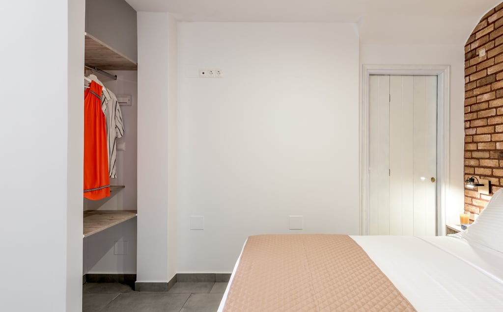 a bedroom with a brick wall and a bed with a bed and a closet