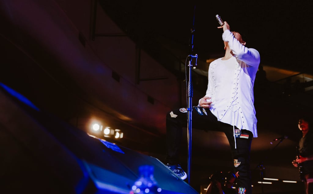 a singer in a white shirt and black pants