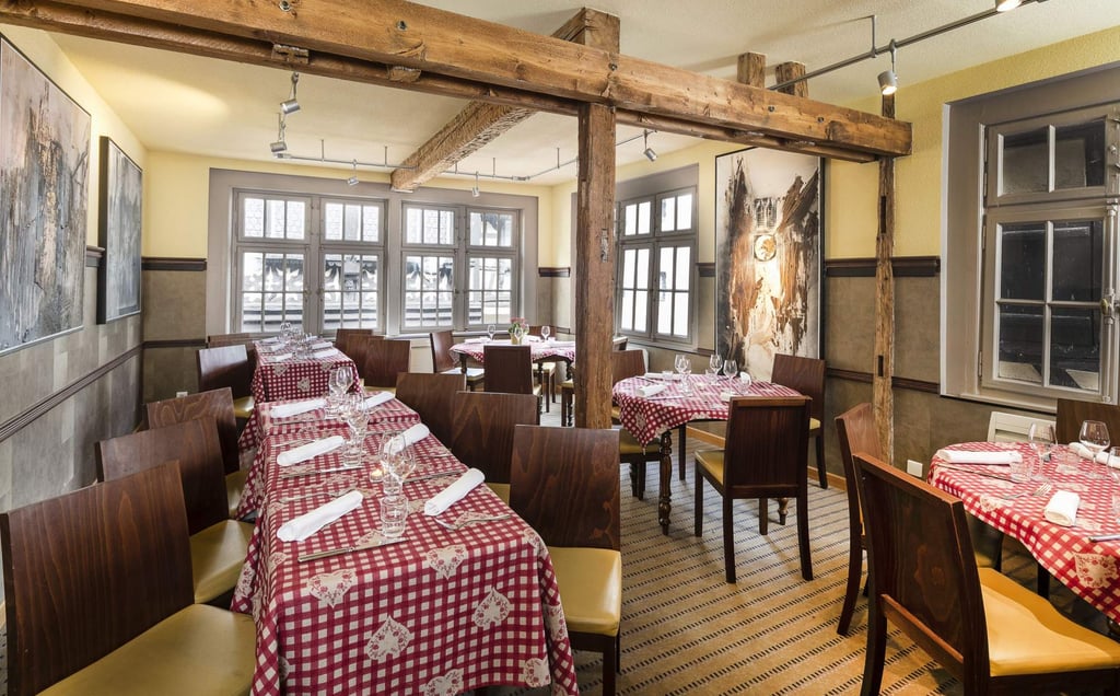 a restaurant with tables and chairs and a table with a red table cloth