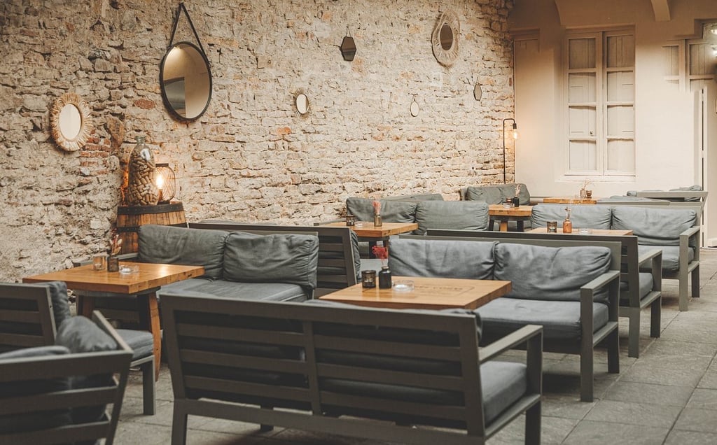 a restaurant with a stone wall and a table with chairs