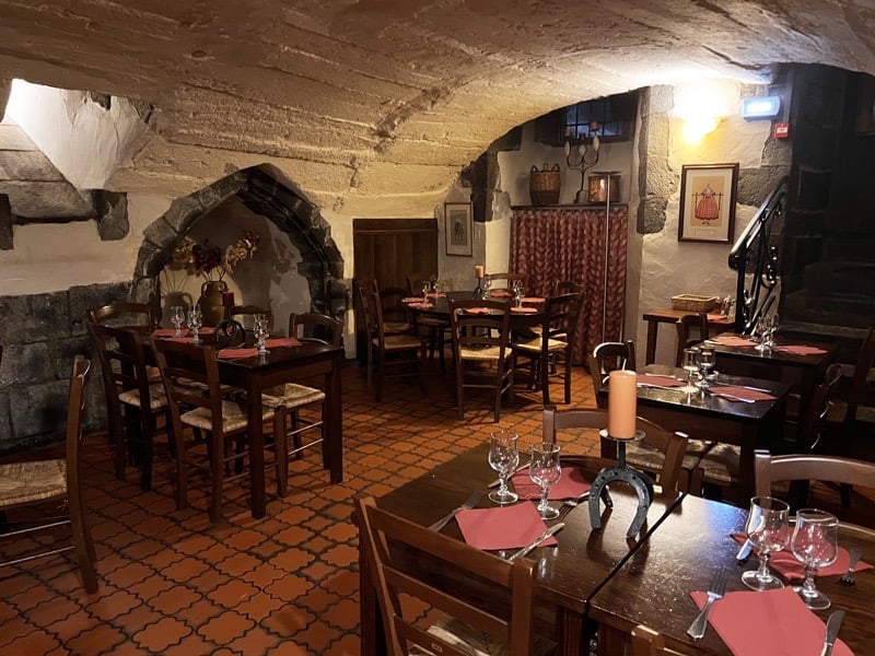 a restaurant with a stone wall and a table with wine glasses