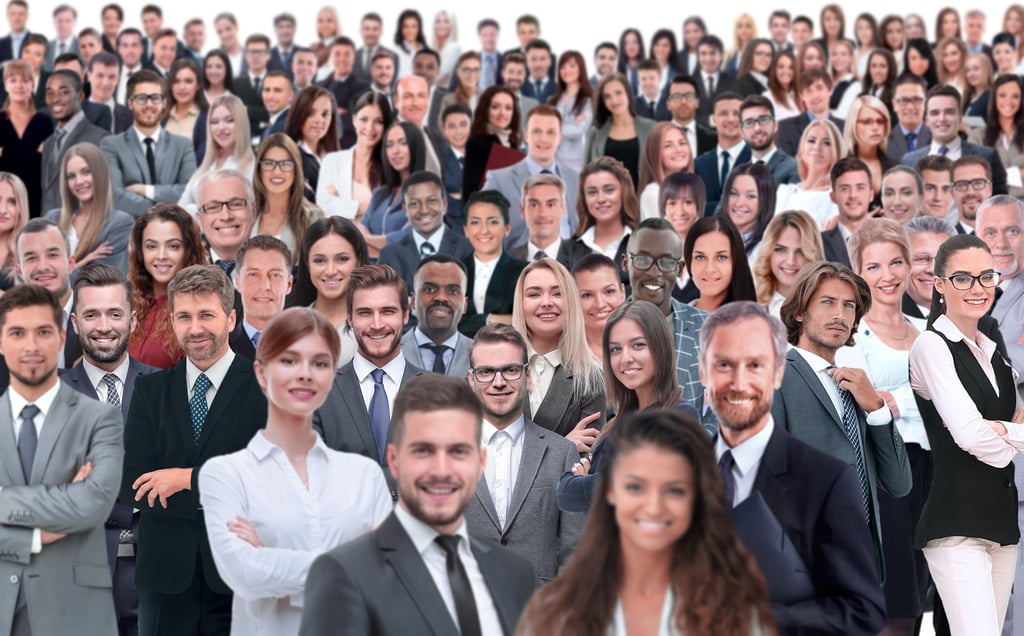 A diverse group of professional business people smiling in a corporate team setting.