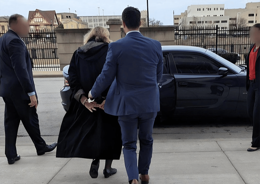 a man in a suit and tie walking away from a car