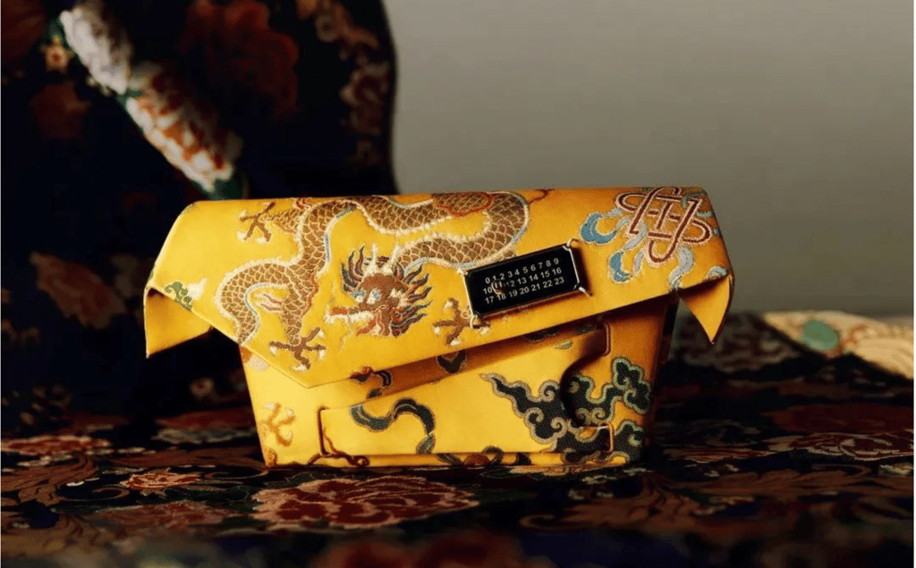 Luxury yellow clutch featuring dragon embroidery and metallic clasp.