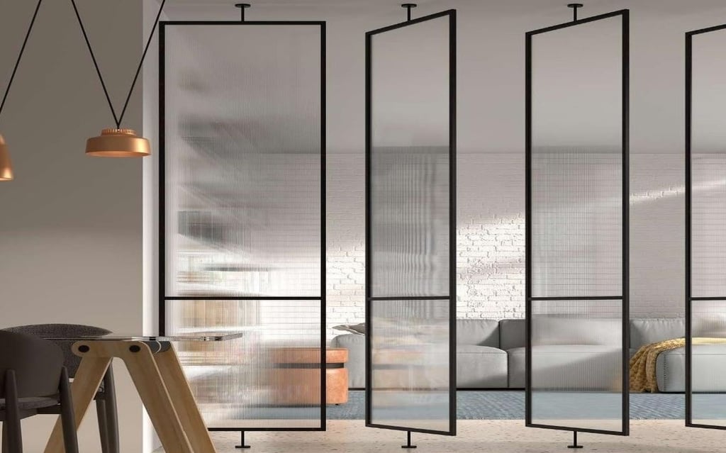 Puerta pivotante de cristal con marco negro en pasillo luminoso de diseño minimalista