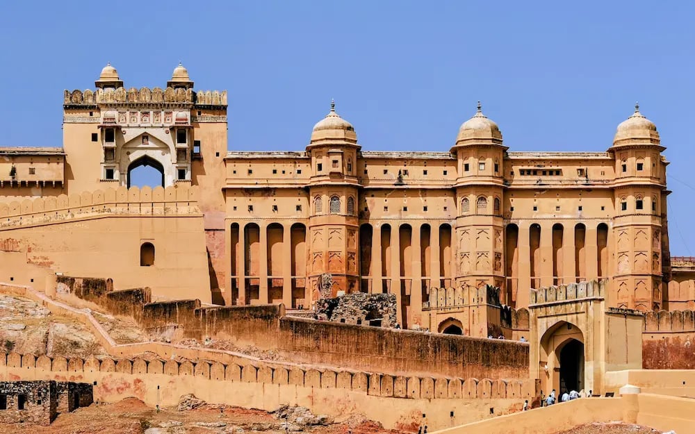 See the grand facade of Amber Fort in Jaipur, a UNESCO World Heritage site known for its majestic Rajput architecture.