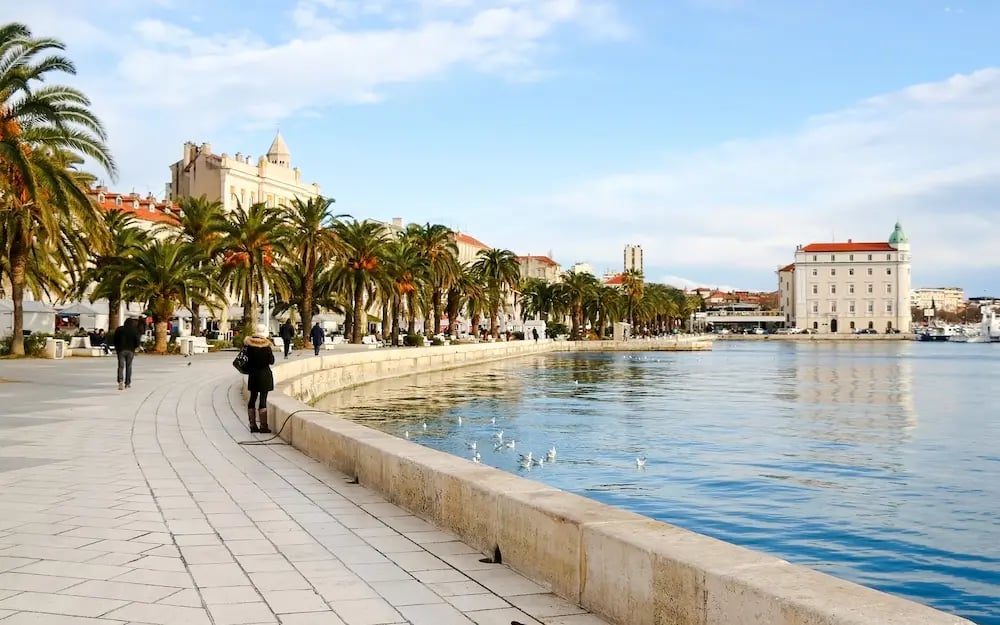 Riva waterfront promenade in Split with palm trees and Adriatic Sea