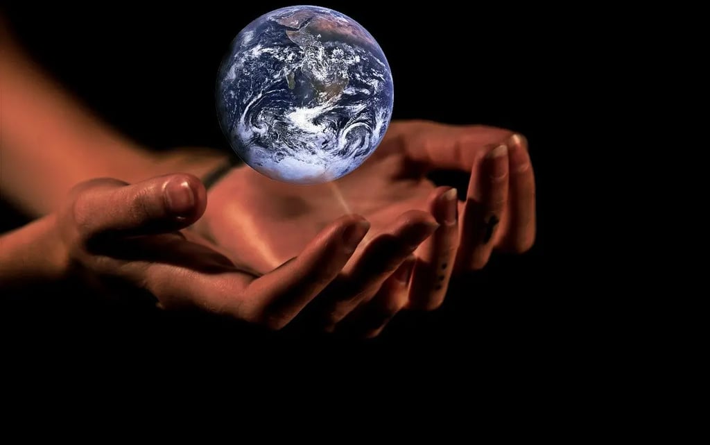a person holding a small globe in their hands