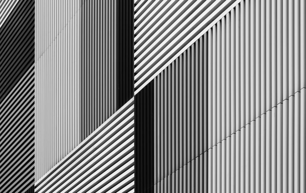 Abstract architectural facade with varying black and white stripes.