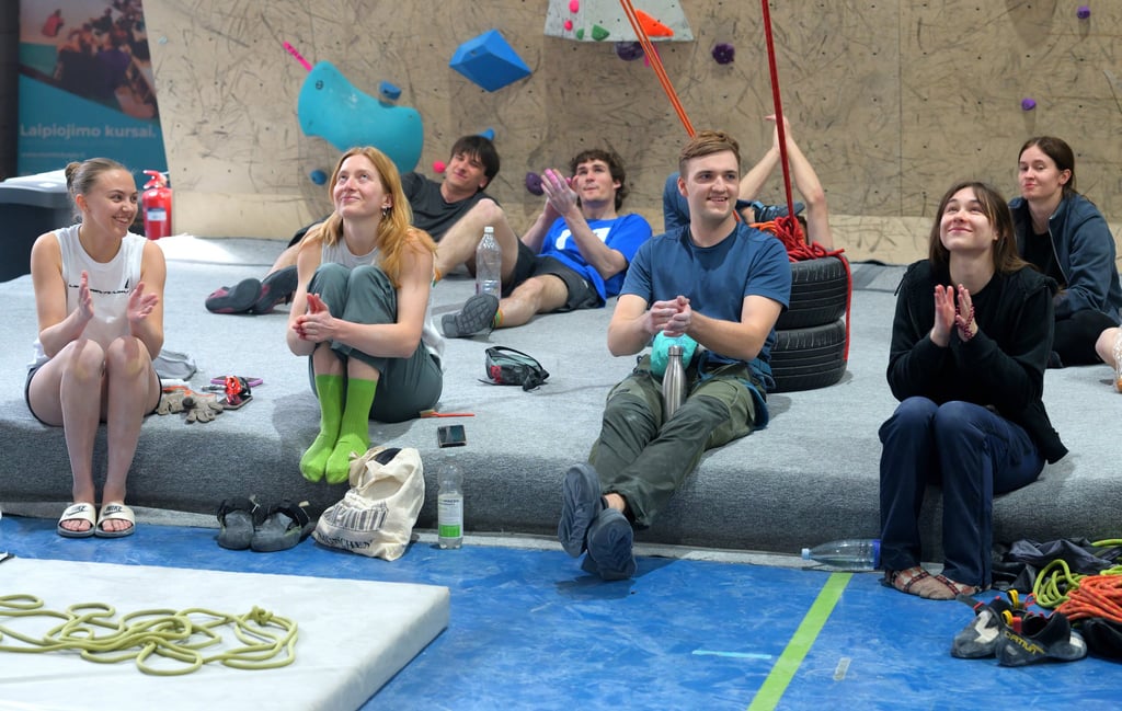 a group of people sitting on a bouldering mat