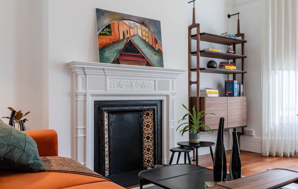 a study with a fireplace and a couch - mid-century modern vibes