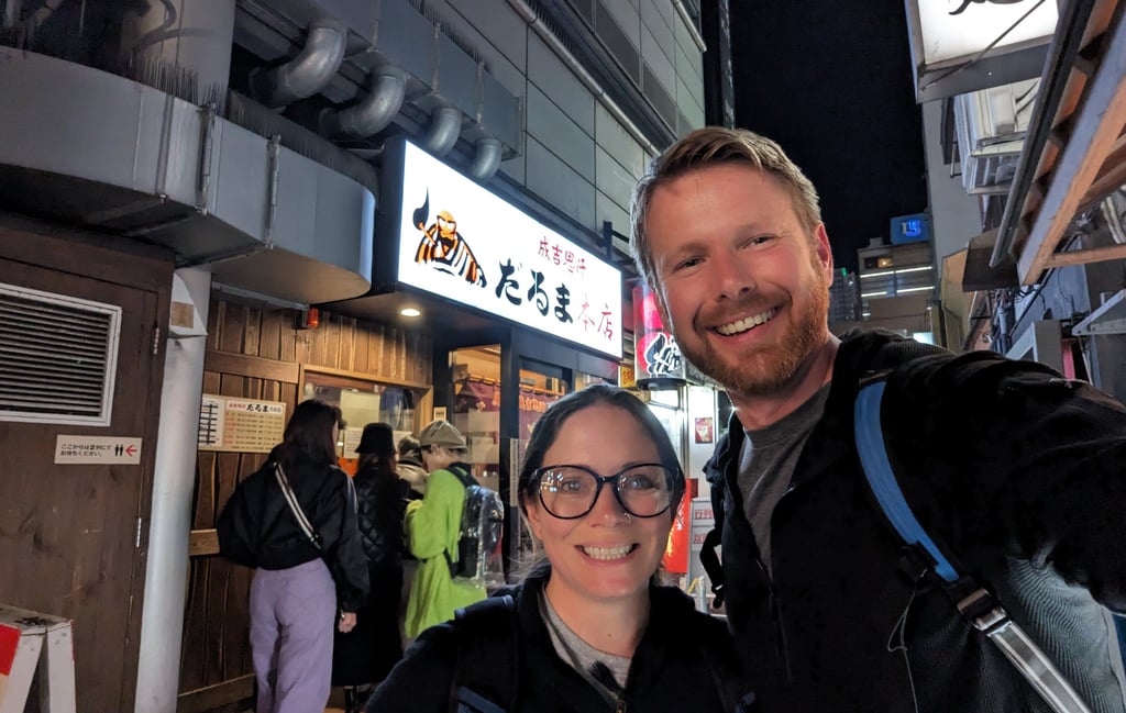 Don wearing an Arcteryx Delta jacket with Samantha in a neon-lit street in Hokkaido.