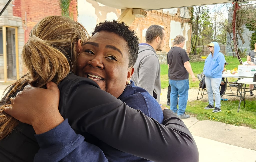 a woman in a blue jacket is hugging a man