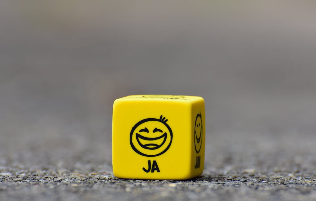 a yellow dice game dicer with a smiley face